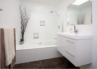 Marble bathroom floor with wall hung vanity unit and wall niches.