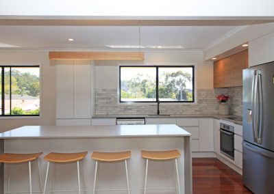 Raw Concrete Caesarstone with white cabinets and stainless steel appliances